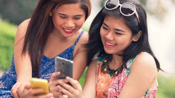 Two filipino singles using their phones